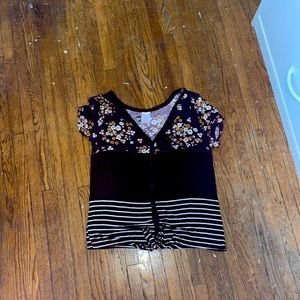The size is medium and it is a flower shirt with purple and white.